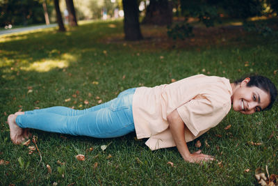 Rear view of man lying on grass in park