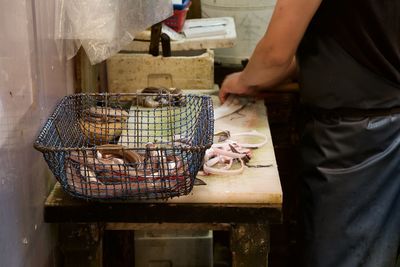 Midsection of man holding fish at kitchen