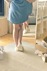 Low section of woman standing on floor at home