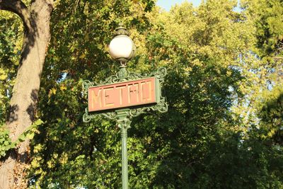 Sign board on tree trunk in park