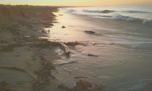 Scenic view of beach against sky during sunset