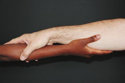 Midsection of man making face against black background