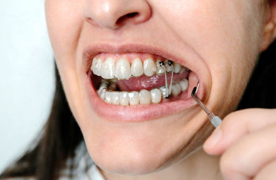 Close-up of young woman applying nail