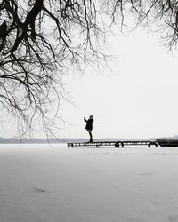 Silhouette of man walking on snow covered landscape