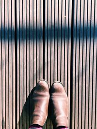 Low section of person standing on wooden floor