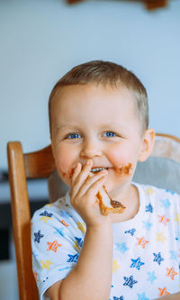 Little cute boy eating bread with chocolate butter