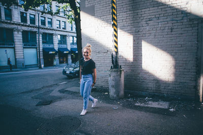 Full length of woman with umbrella in city