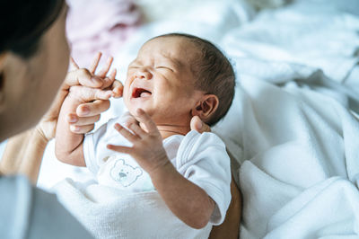 Midsection of mother holding baby at home