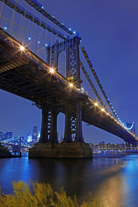 Low angle view of bridge over river at night