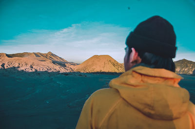 Rear view of man looking at sea against sky