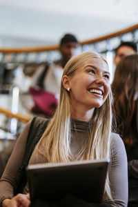 Young woman using digital tablet while sitting in cafe