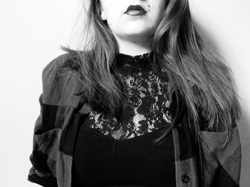 Close-up of young woman standing against white background
