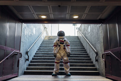 Male astronaut standing in front of staircase