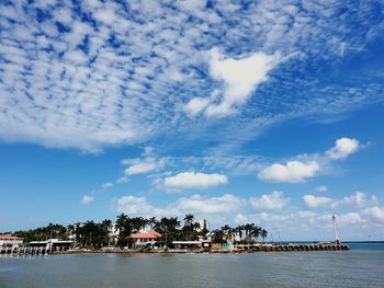 Scenic view of sea by buildings against sky