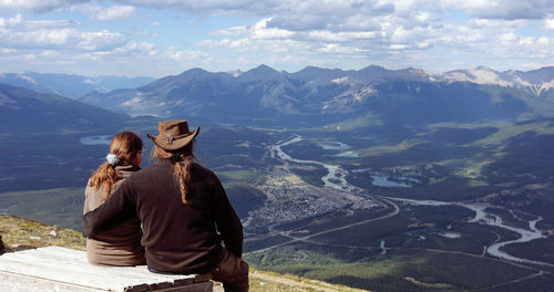 Couple overlooking landscape against sky