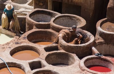 High angle view of men washing clothes in containers