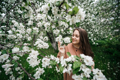 Beautiful young girl in the garden of blooming apple trees