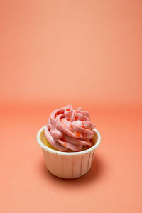 Close-up of cupcakes against pink background