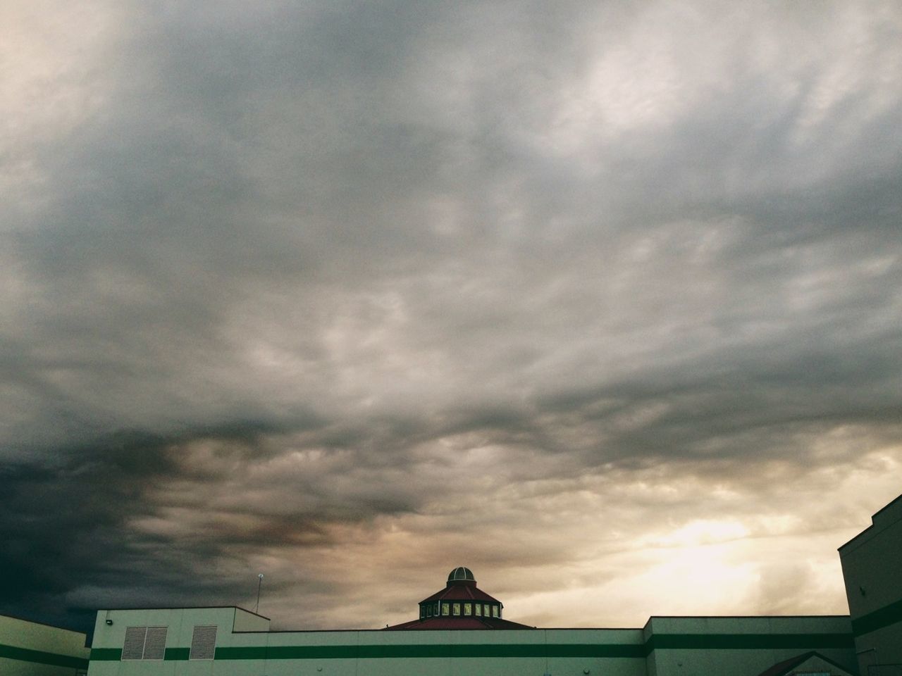 architecture, built structure, sky, cloud - sky, building exterior, cloudy, low angle view, weather, overcast, high section, cloud, cloudscape, storm cloud, outdoors, dramatic sky, roof, nature, house, building, no people