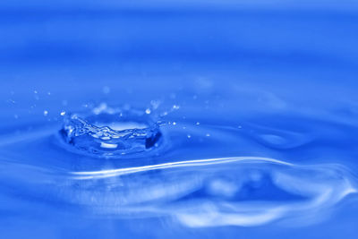 Close-up of splashing water against blue background