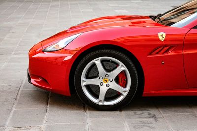 Close-up of red vintage car on floor in city