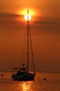 Silhouette sailboat sailing on sea against sky during sunset