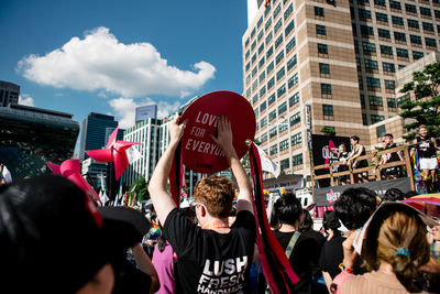 Rear view of people on street against buildings in city