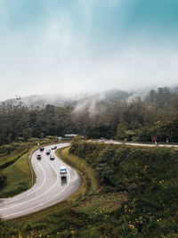 High angle view of road amidst trees against sky