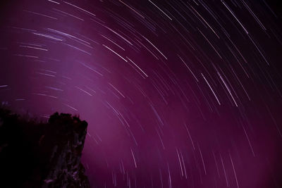 Low angle view of star trails against sky at night