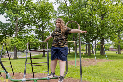 Portrait of smiling young woman exercising in park