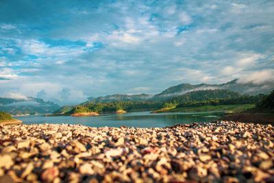 Surface level of stones on beach against sky