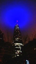 Low angle view of illuminated buildings against sky at night