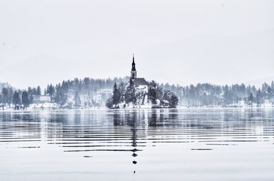 Scenic view of lake by building against clear sky