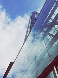 Low angle view of modern building against cloudy sky