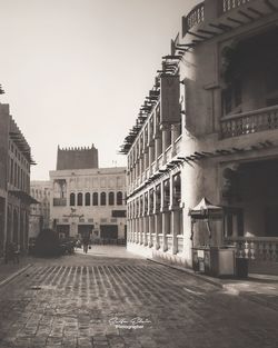 Street amidst buildings in town against sky