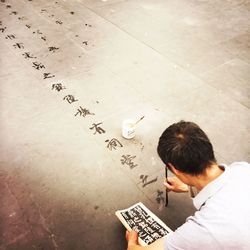 High angle view of man walking on paper