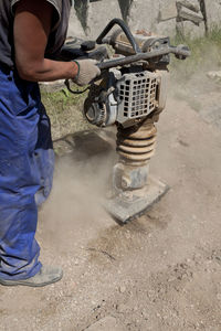 Low section of man working on motorcycle