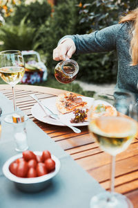 Family and friends having meal - pizza, salads, fruits and drinking white wine during summer picnic