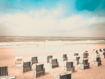 Chairs on beach against sky