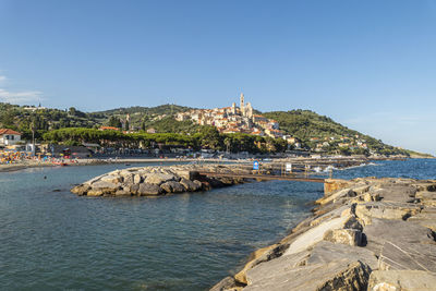 Scenic view of sea by buildings against clear sky