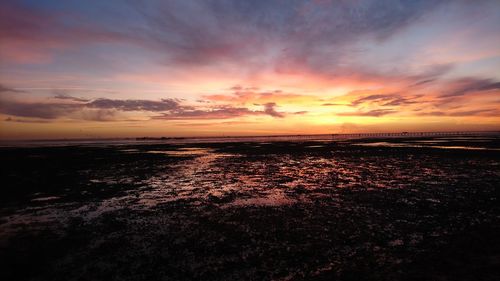 Scenic view of sea against dramatic sky during sunset