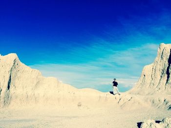 Woman standing on rock formation against sky at badlands national park