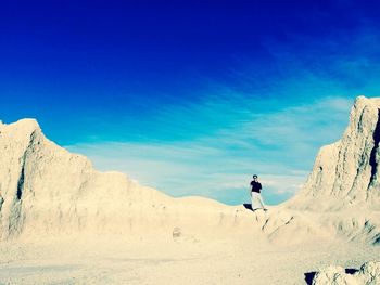 Rear view of people on mountain against blue sky