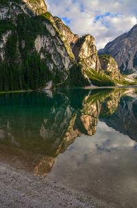 Scenic view of lake by mountains against sky