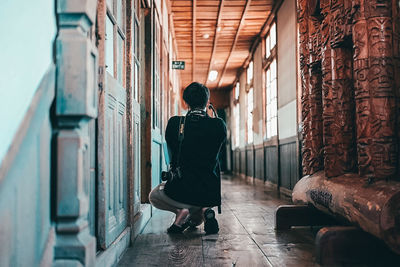 Rear view of woman walking in corridor of building