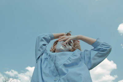 Low section of woman against blue sky