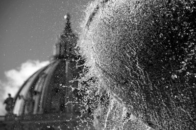 Close-up of water splashing on road against sky