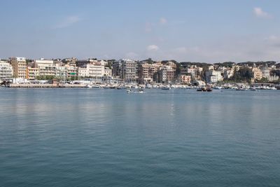 Sea by townscape against sky