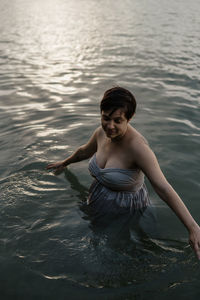 Portrait of pregnant woman  in lake water