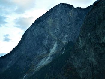 Low angle view of rocky mountains against sky